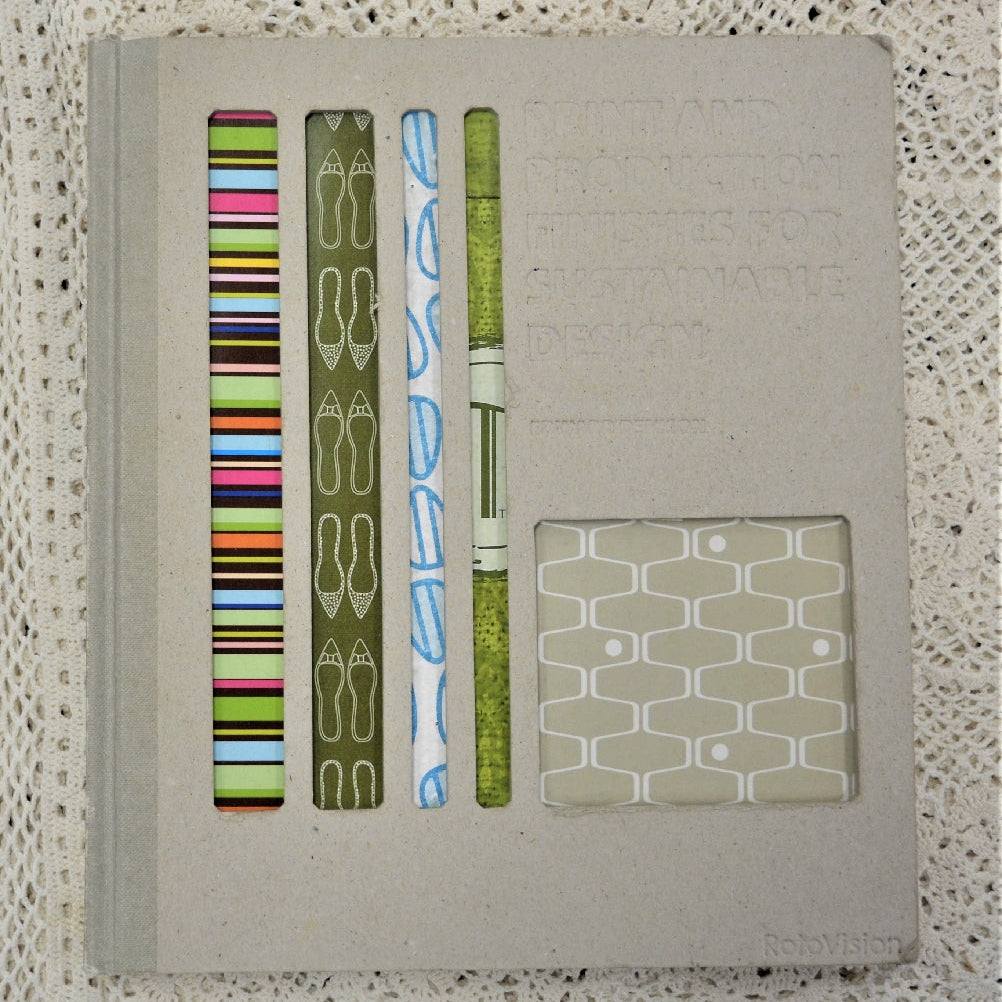 A hardback book with a beige cover, showcasing various environmentally friendly print and production finishes, along with examples of printed materials.