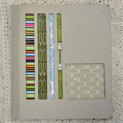 A hardback book with a beige cover, showcasing various environmentally friendly print and production finishes, along with examples of printed materials.