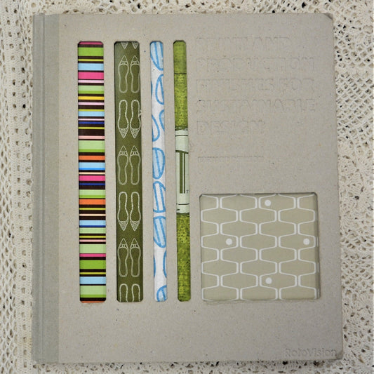 A hardback book with a beige cover, showcasing various environmentally friendly print and production finishes, along with examples of printed materials.