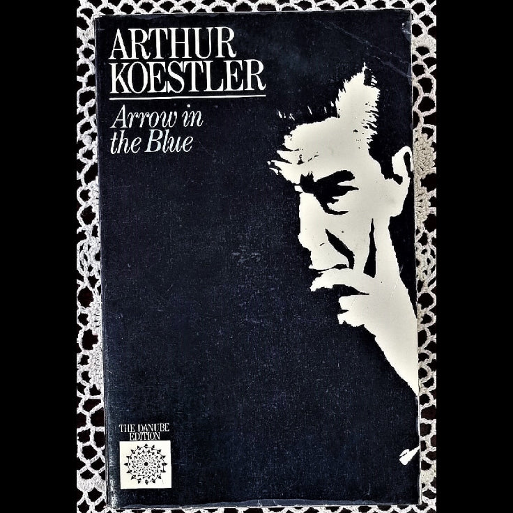 A paperback book titled 'Arrow in the Blue' by Koestler, featuring a black and white cover image of a man with a contemplative expression.