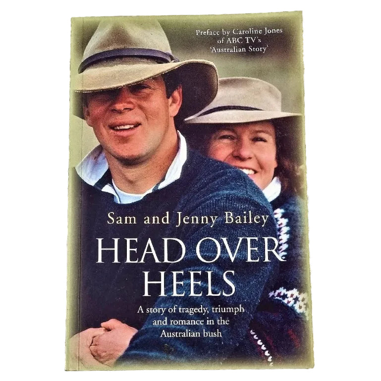The cover of the book 'Head Over Heels' features a portrait of a man and a woman, likely Sam and Jenny Bailey, wearing hats and smiling. The background is blurred with a soft focus effect, emphasizing the couple.