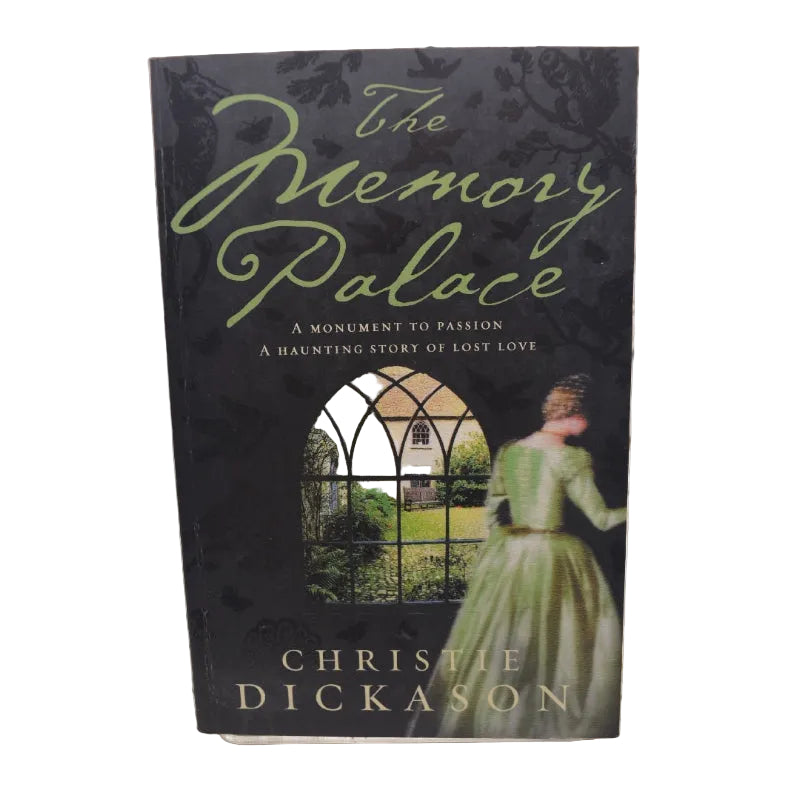 The cover of the book 'The Memory Palace' features a black and green design with an image of a woman in a green dress looking out a window, with a gothic-style arch in the background. The book's title is prominently displayed at the top.