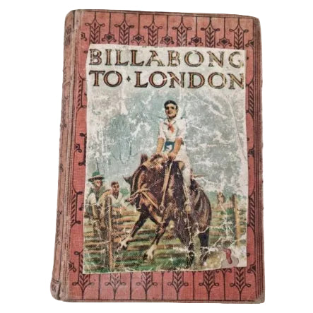 A vintage book cover of 'Billabong to London' showing a man on a horse, with a red fabric book cover.